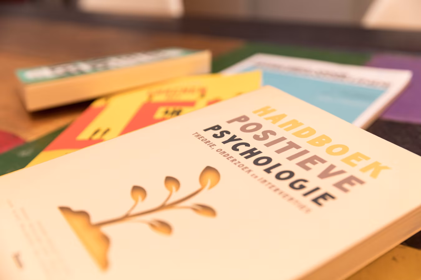 Close-up van het handboek positieve psychologie met een boom en lamp afbeelding, focus op leren en ontwikkelen