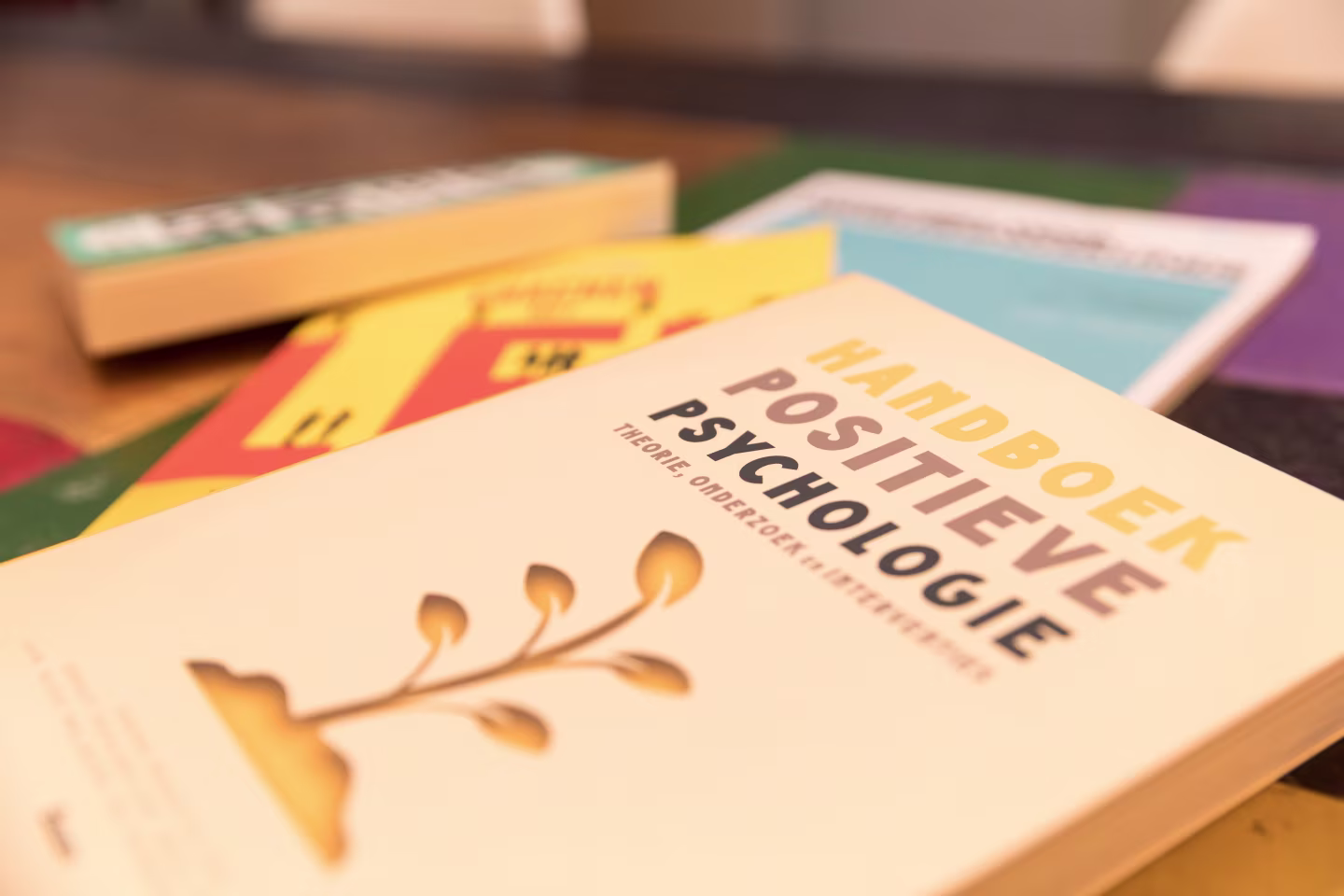 Close-up van het handboek positieve psychologie met een boom en lamp afbeelding, focus op leren en ontwikkelen