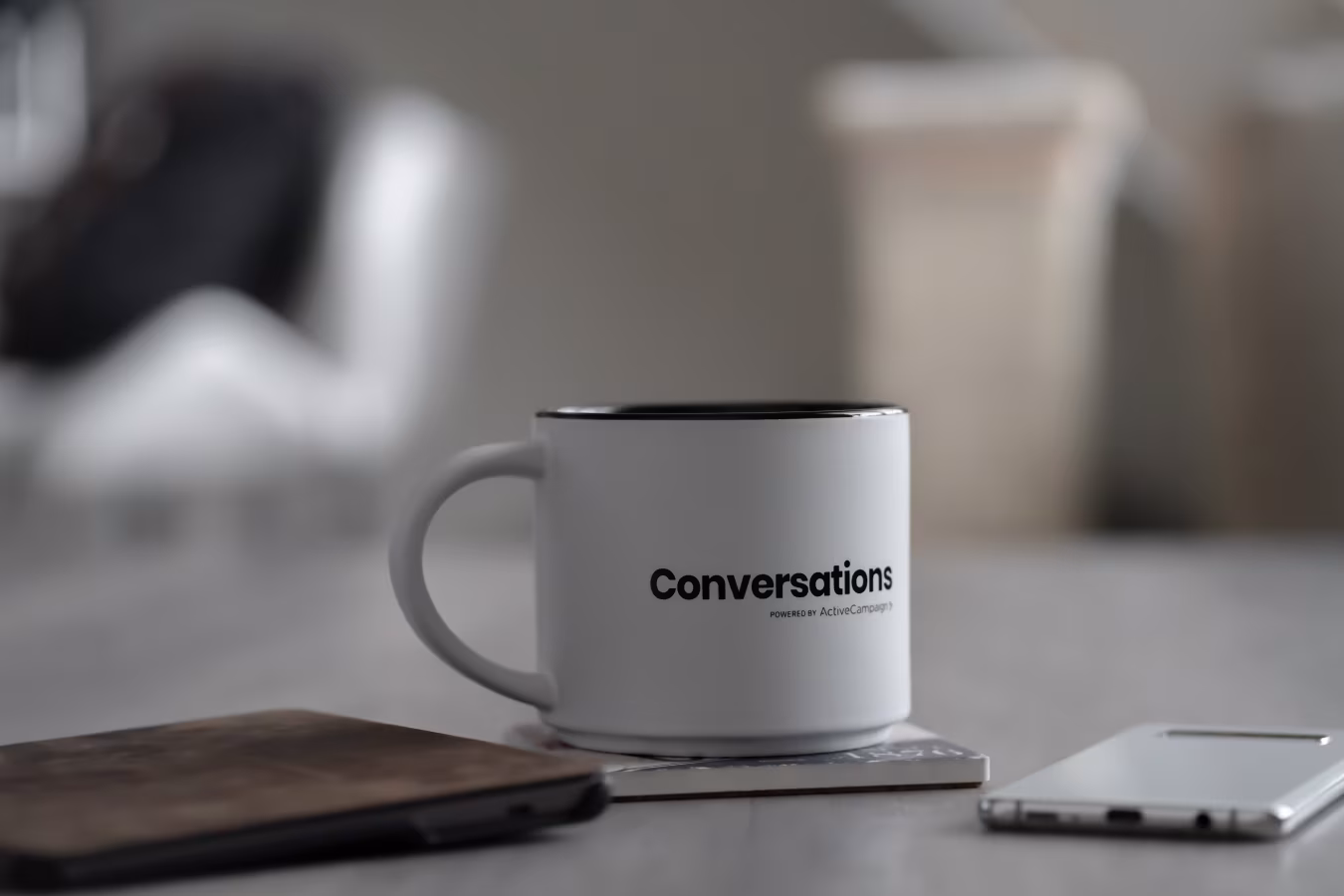Close-up van witte koffiekop met zwart woord conversations op stapel boeken in rustige werkwijze setting